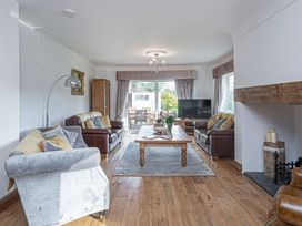 A living room with sofas a wooden coffee table a television and a fireplace at Cilfan in Llanrwst