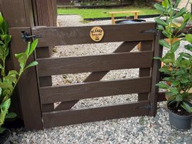 A wooden gate with a sign and plants at Fig Tree Lodge Hutton Roof near Penrith