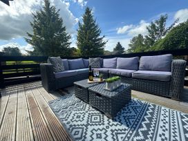 An outdoor seating area with a sofa and table at Fig Tree Lodge in Hutton Roof near Penrith