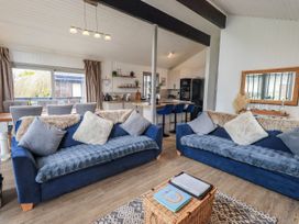 A living room with two sofas and a dining area at Fig Tree Lodge Hutton Roof near Penrith