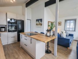 A kitchen with an island and sofa at Fig Tree Lodge in Hutton Roof near Penrith