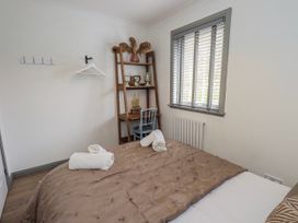 A bedroom with a bed and shelf at Fig Tree Lodge in Hutton Roof near Penrith