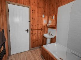A bathroom with a bathtub and sink at Fig Tree Lodge in Hutton Roof near Penrith