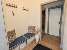 A hallway with a bench and coat hooks at Fig Tree Lodge Hutton Roof near Penrith
