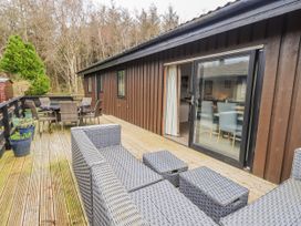 An outdoor deck area with seating and a table at Fig Tree Lodge Hutton Roof near Penrith