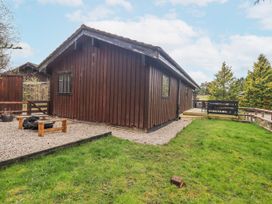 An outdoor view of a wooden cabin with decking at Fig Tree Lodge Hutton Roof near Penrith