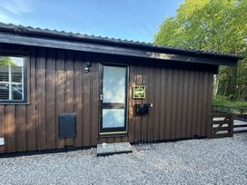 An exterior view of a wooden cabin with a door and windows at Fig Tree Lodge in Hutton Roof near Penrith