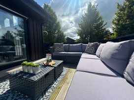 An outdoor seating area with a sofa and coffee table at Fig Tree Lodge Hutton Roof near Penrith