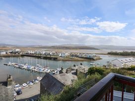 A marina with boats docked near houses and open water at Captain's Rest in Porthmadog