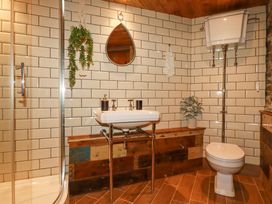 A bathroom with a sink mirror toilet and hanging plant at Mermaid's Rest in Newquay