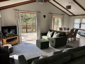 A living room with a sofa and television at 2 Riverside Lodge near Cenarth