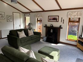 A living room with a sofa and television at 2 Riverside Lodge Abercych near Cenarth