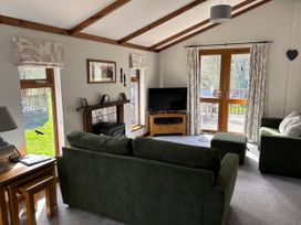 A living room with a sofa and television at 2 Riverside Lodge Abercych near Cenarth