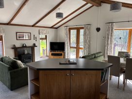 A living room with a fireplace and sofa at 2 Riverside Lodge Abercych near Cenarth