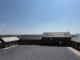 Multiple stone buildings with gravel area at 3 Trem y Mor Llanfwrog near Llanfachraeth