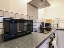 A kitchen countertop with a microwave kettle toaster stove and oven at Hub House Three Oaks near Hastings