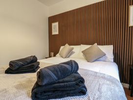 A bedroom with a bed pillows folded towels and wooden slatted wall at Hub House in Three Oaks near Hastings