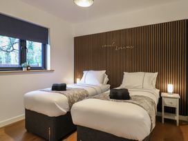 A bedroom with two single beds a wooden slatted headboard and a window at Hub House in Three Oaks near Hastings