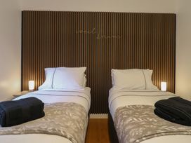 A bedroom with two single beds and a wooden slatted headboard with sweet dreams text at Hub House in Three Oaks near Hastings