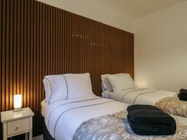 A bedroom with two single beds and a nightstand with a lamp at Hub House in Three Oaks near Hastings