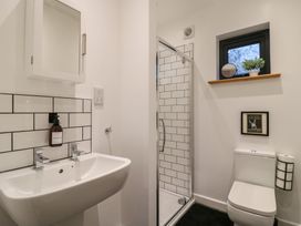 A bathroom with a sink mirror shower toilet and a small window at Hub House in Three Oaks near Hastings