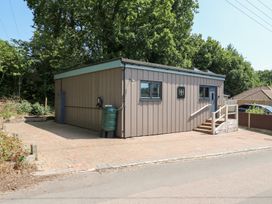 An outdoor view of a building with steps and a rainwater tank at Hub House in Three Oaks near Hastings