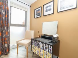 A bedroom with a chair and dresser at Coastguard Lookout in Wyke Regis
