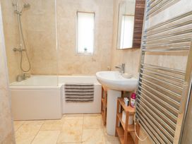 A bathroom with a bathtub, sink, and towel rack at Coastguard Lookout in Wyke Regis