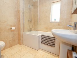 A bathroom with a bathtub, shower, toilet and sink at Coastguard Lookout in Wyke Regis