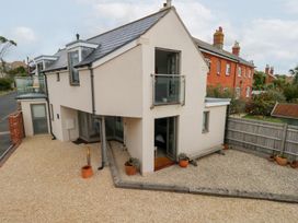A house with a balcony and gravel area at Coastguard Lookout in Wyke Regis