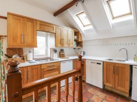 A kitchen with wooden cabinets and a sink at White Gates in Banham