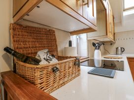 A kitchen with a basket, bottle, and utensils at White Gates in Banham