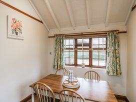 A dining room with a wooden table and chairs at White Gates in Banham