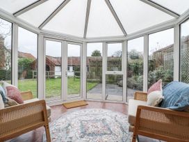 A conservatory with seating and a view of the garden at White Gates in Banham
