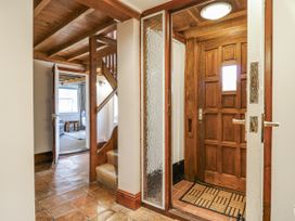 A hallway with a staircase and a door at White Gates in Banham
