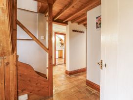 A hallway with a staircase and a door leading to the kitchen at White Gates in Banham