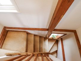 A staircase with a wooden railing and window at White Gates in Banham