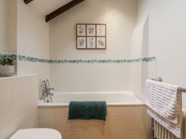 A bathroom with a bathtub and wall art at White Gates in Banham
