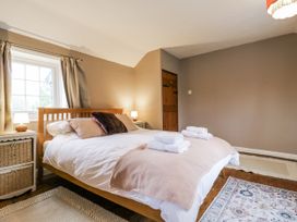 A bedroom with a bed and nightstand at White Gates in Banham