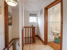 A hallway with a staircase and bathroom access at White Gates Banham