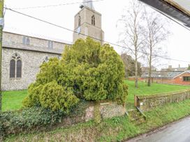A church with a tower and greenery at White Gates in Banham