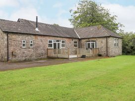 A house with a wooden deck and surrounding grass at The Gatehouse in 