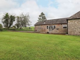 An outdoor view of a stone building with a wooden deck at The Gatehouse 