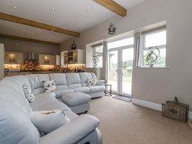 A living room with a sectional sofa and kitchen in The Gatehouse 