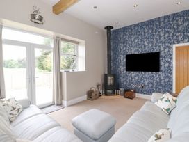 A living room with a sofa and a television at The Gatehouse in 