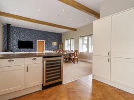 A kitchen with cabinets and a dining area at The Gatehouse 