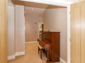 A hallway with a piano and doors at The Gatehouse