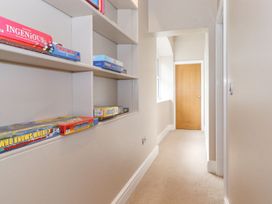 A hallway with shelves and board games at The Gatehouse