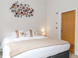 A bedroom with a double bed and decorative wall art at The Gatehouse in 
