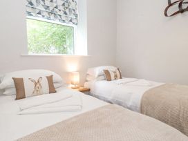 A bedroom with two beds and a lamp at The Gatehouse in 